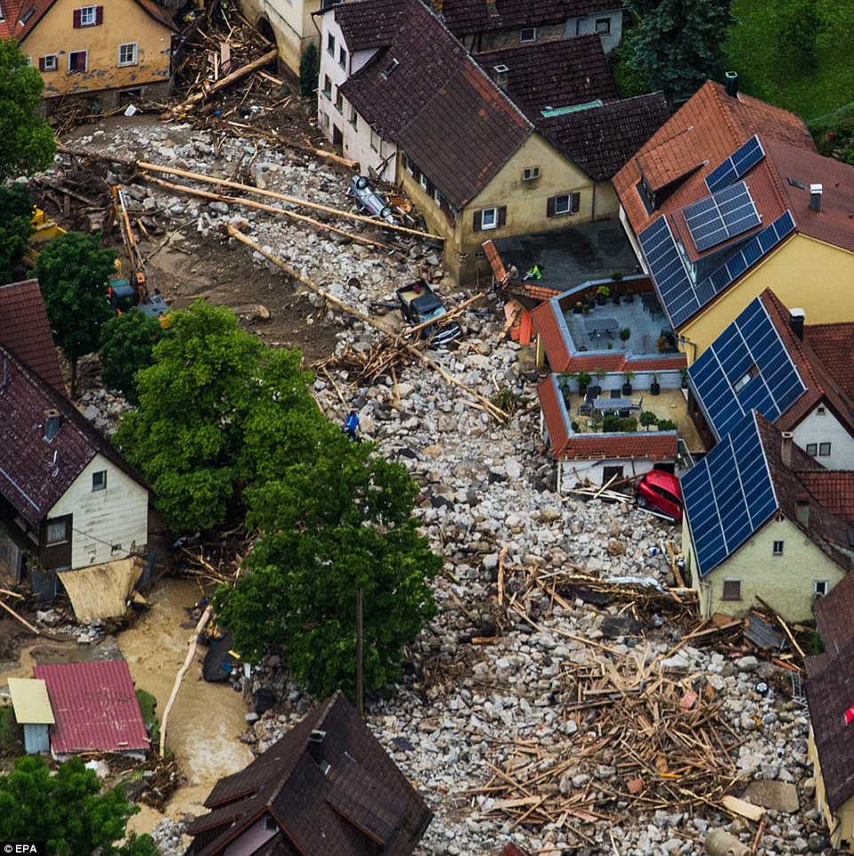 Trail of destruction: Debris and rubble can be seen piled up in a residential street after heavy storms hit the German town of Braunsbach